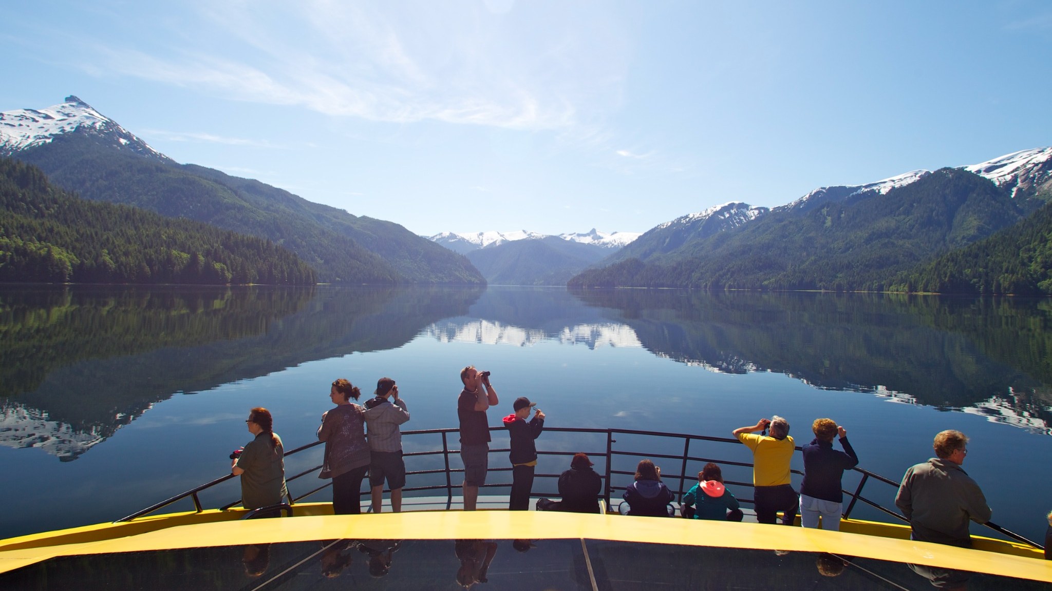 Guests on the M/V Inside Passage entering Khutzeymateen fjord waters beneath snow-capped peaks.