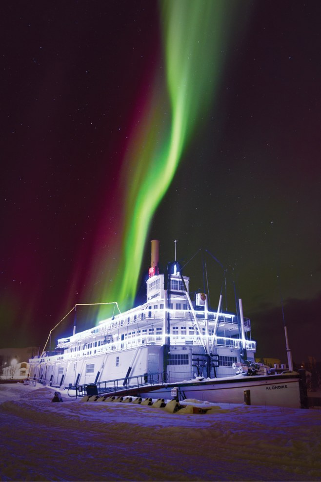 Aurora borealis above the illuminated SS Klondike sternwheeler in winter Whitehorse.