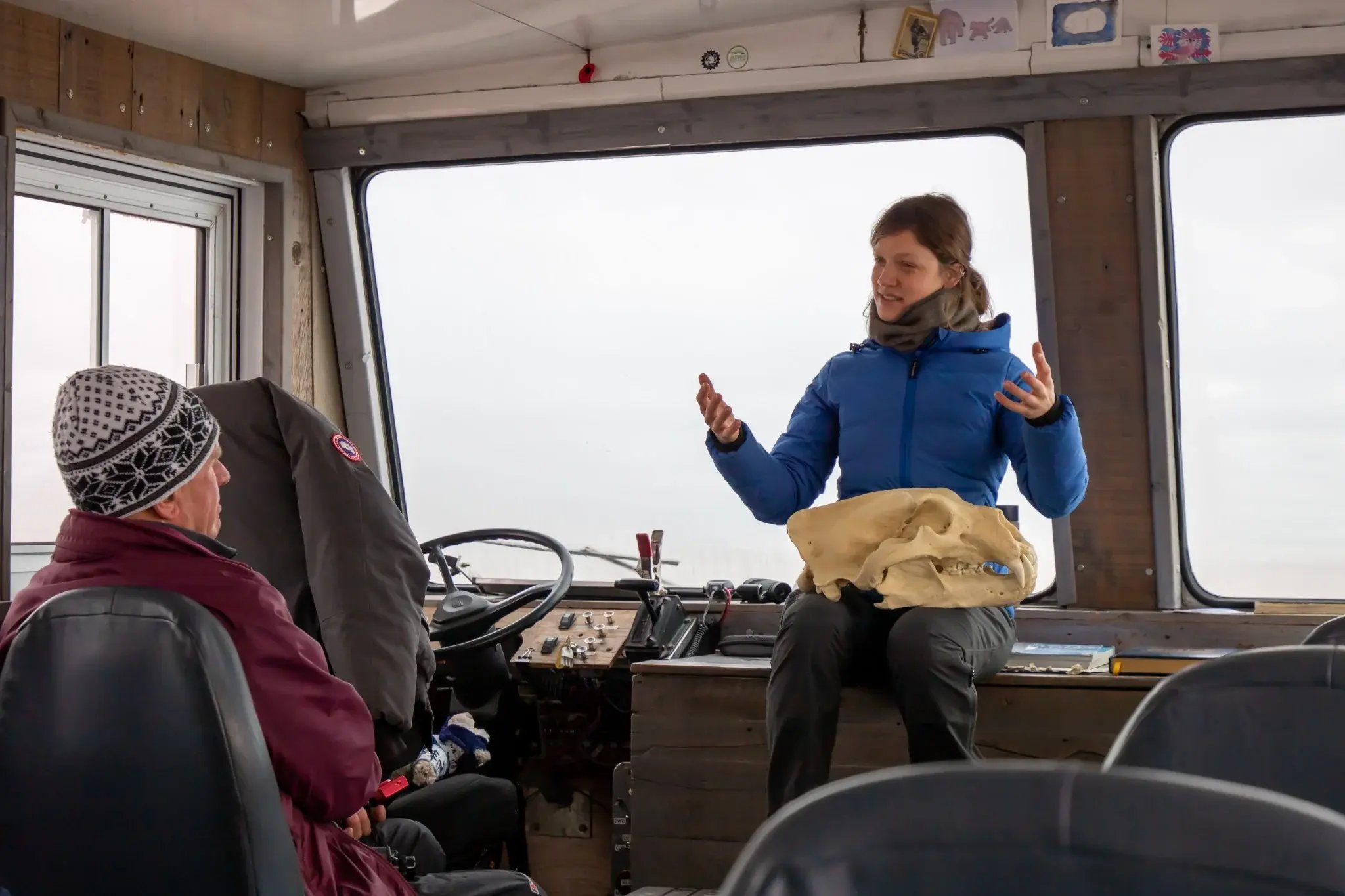 Guide presenting a polar bear skull inside a Tundra Buggy.
