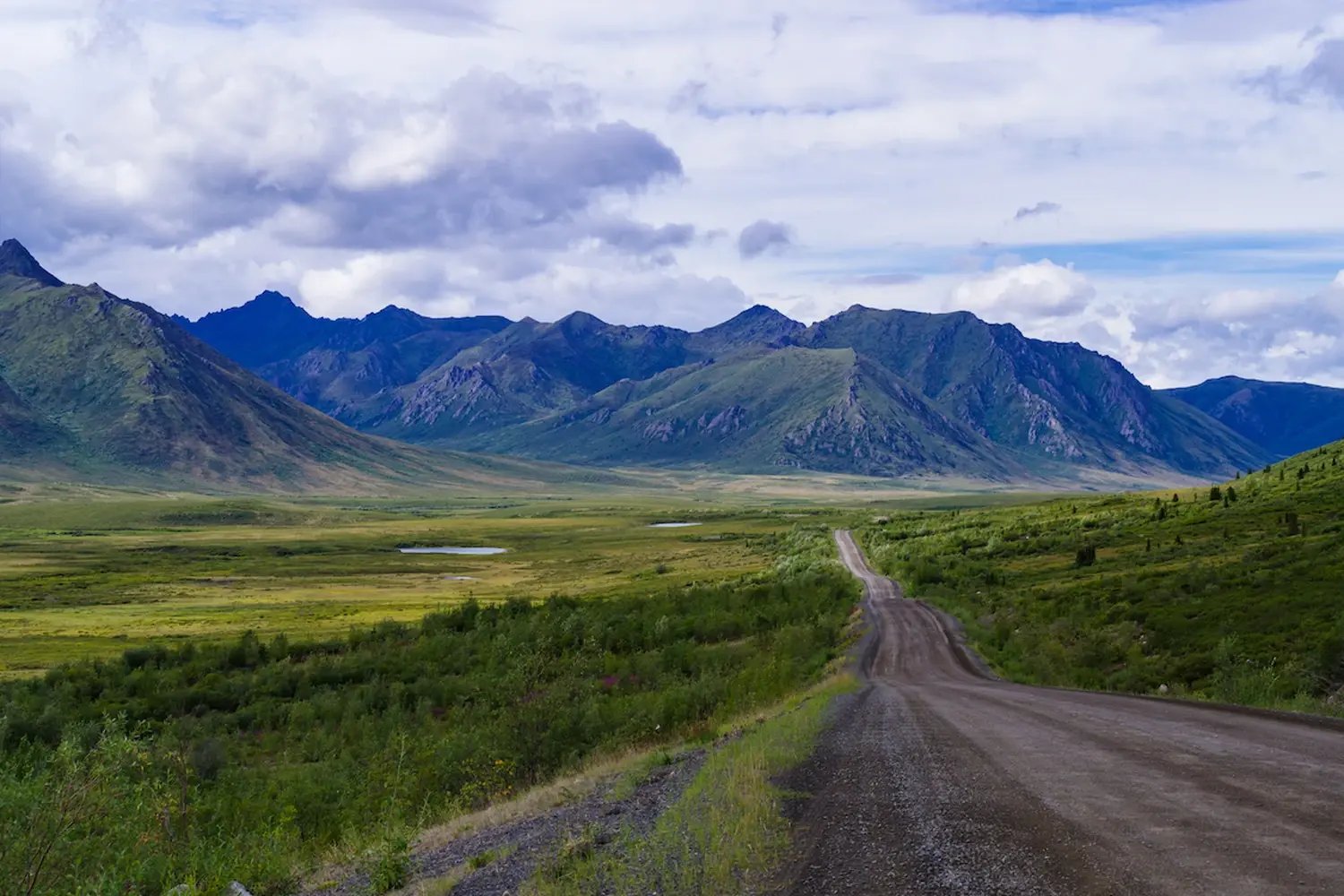 The Dempster Highway stretching north from Dawson City toward Tombstone Territorial Park, with broad valley views and mountain scenery.