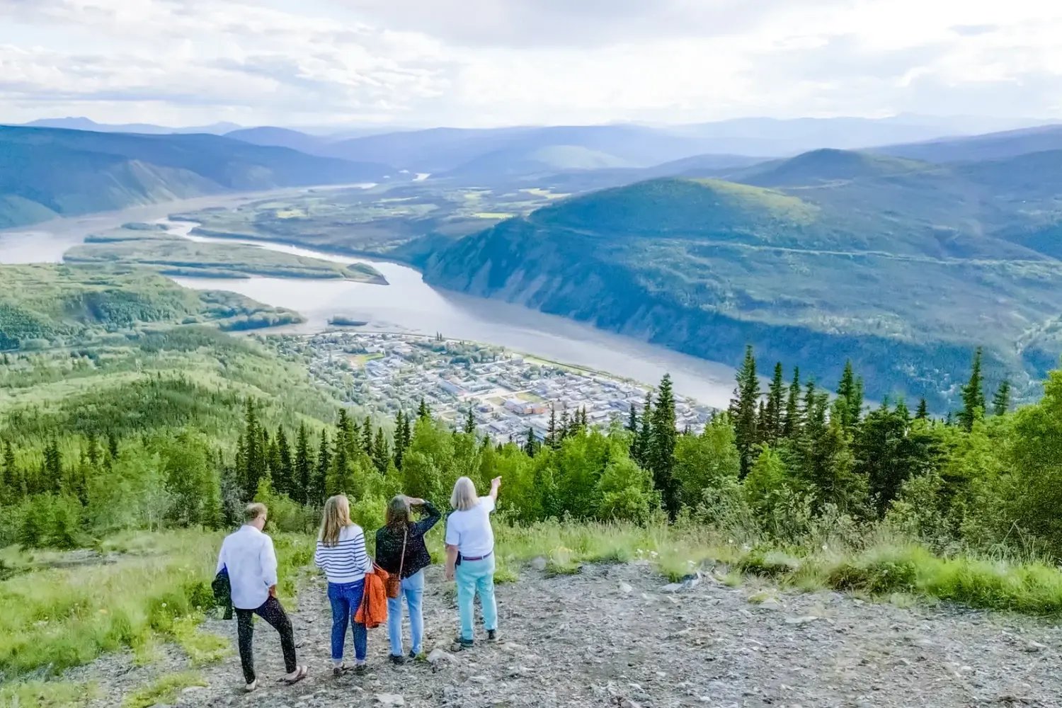 Guests looking out from the Midnight Dome above Dawson City and the Yukon River Valley.