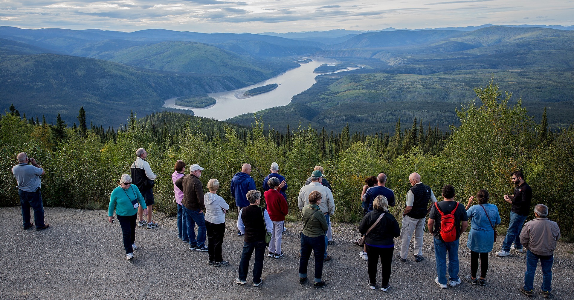 Guided tour group at Midnight Dome in Dawson City, Yukon, overlooking the Yukon River valley and surrounding hills. Guided tour group at Midnight Dome in Dawson City, Yukon, overlooking the Yukon River valley and surrounding hills.